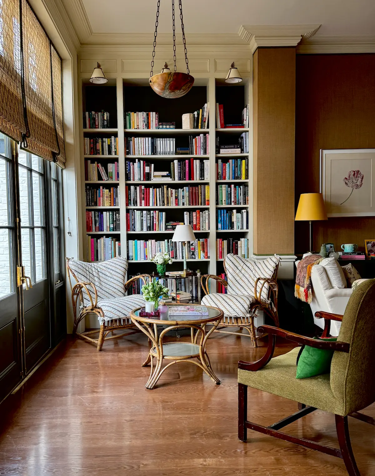Warm living room interior featuring floor-to-ceiling bookshelves and woven chairs
